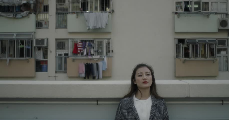 A woman sits on her balcony