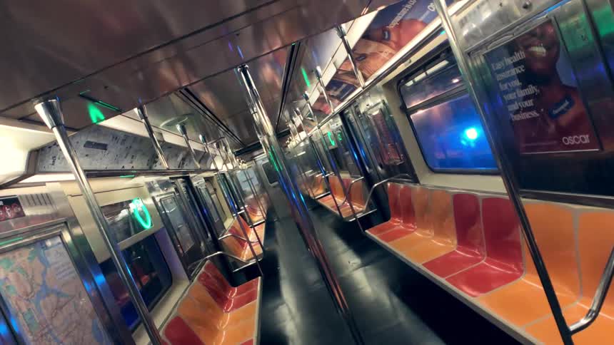 The tunnel lights shine through the windows of an empty subway car