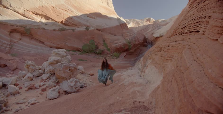 A woman walks through the rocks in a canyon