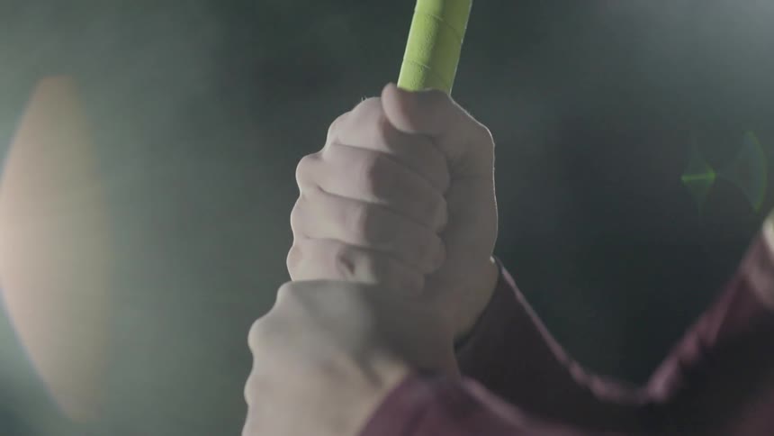 A person tightens their grip on a baseball bat