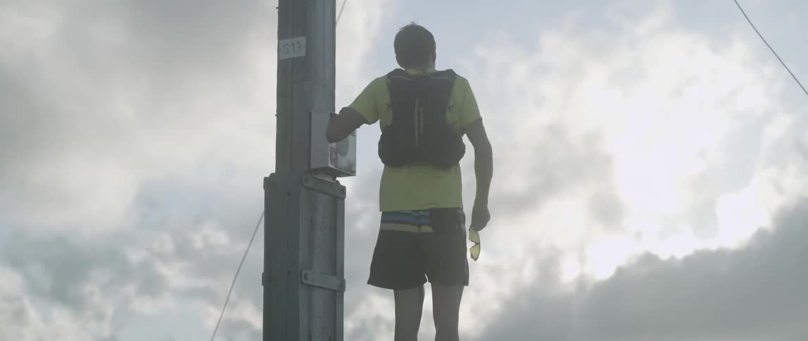A man runs up to a pole and stops