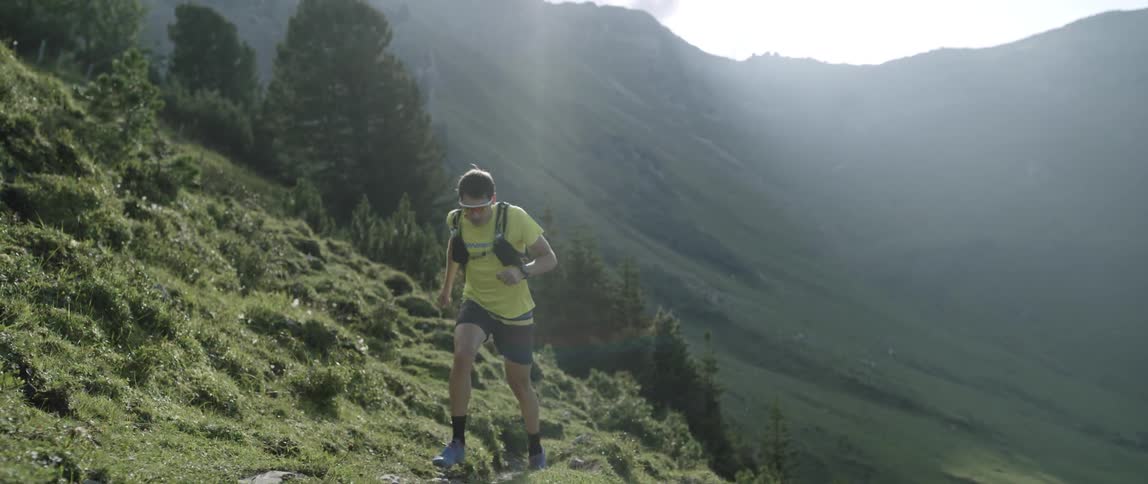 A man runs up a steep hillside