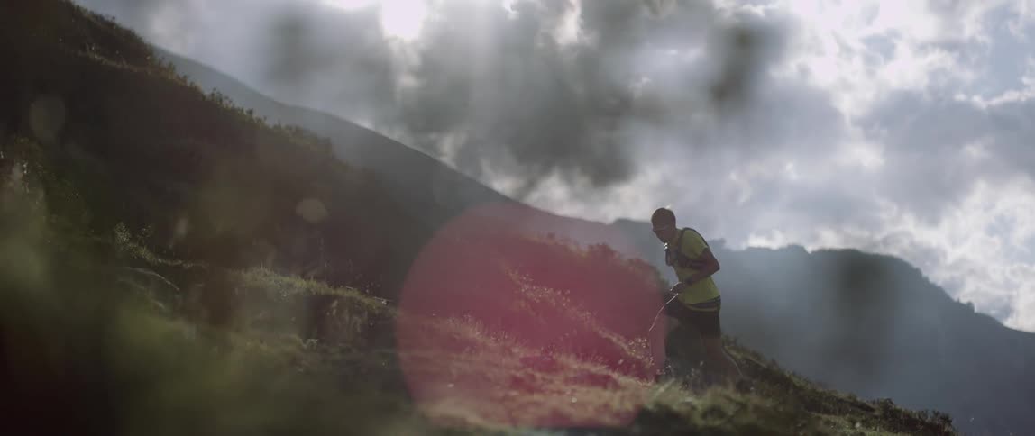 A man runs up a steep hillside