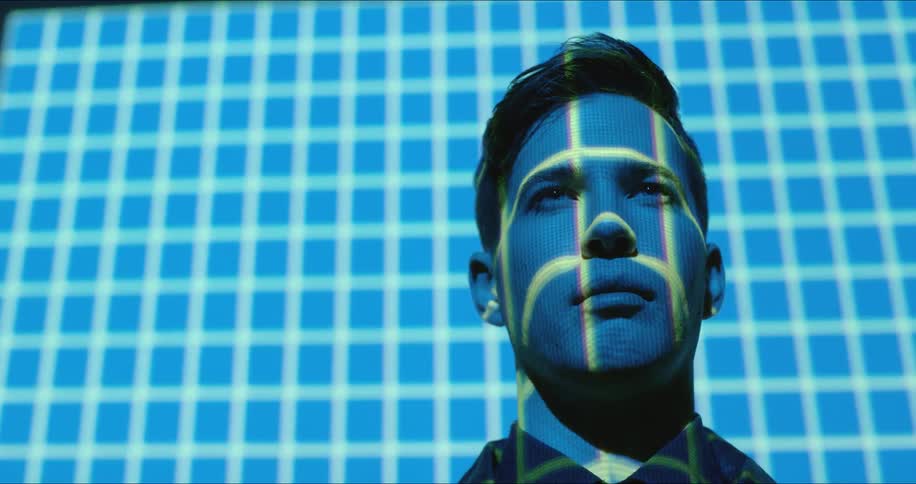 Close up of man's face illuminated by blue and green light