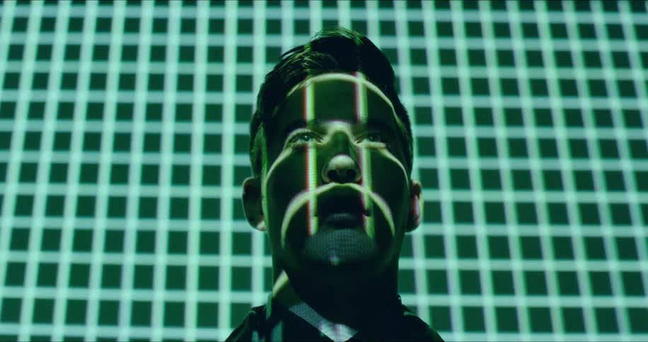 A man is staring forward as grid lights shine on his face
