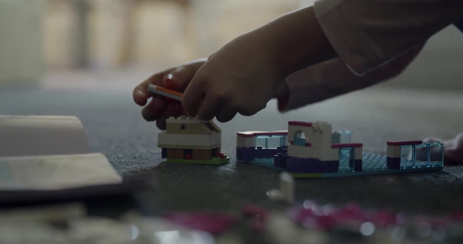 A child plays with legos on the floor