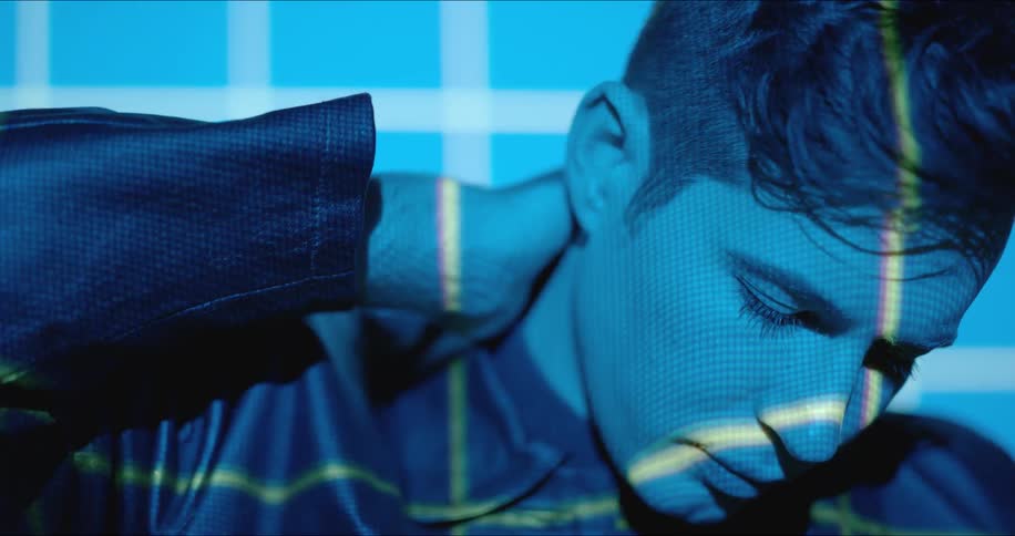 Close up of man's face illuminated by blue and green light