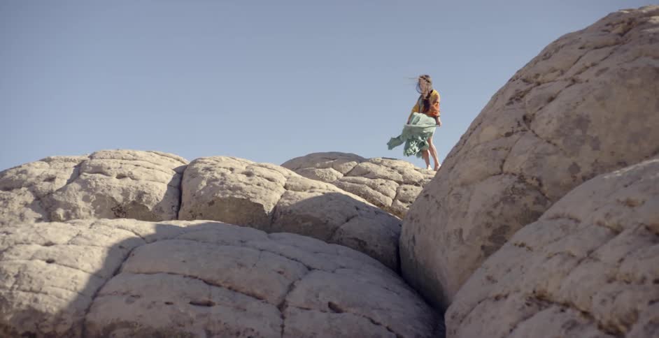 A woman stands on the top of a canyon