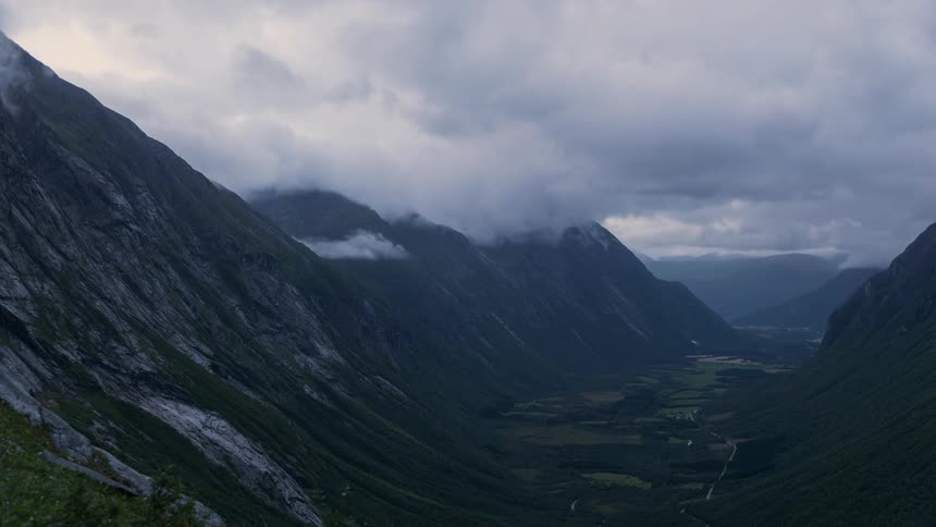 Clouds moving above a green Norwegian valley between mountains