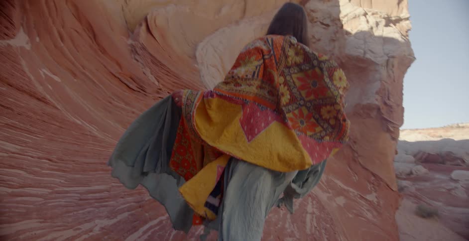 Woman walks through formation of rocks