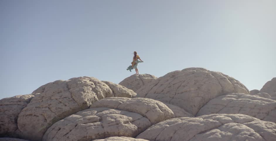 A woman stands on the top of the mountain