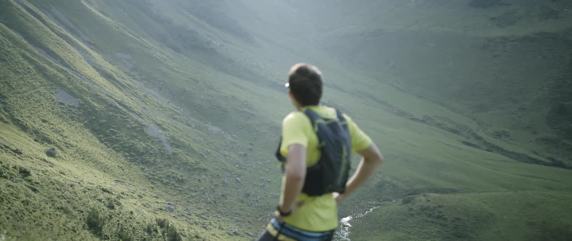 A man running uphill takes a short break