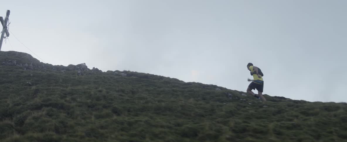 A man runs up a steep hillside