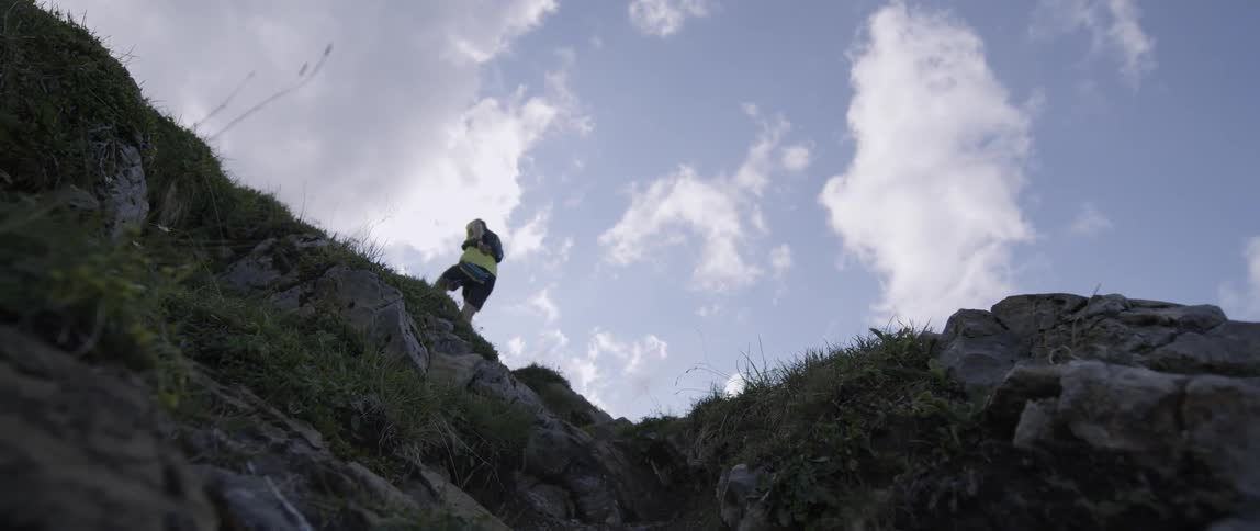 A man runs up a rocky mountainside