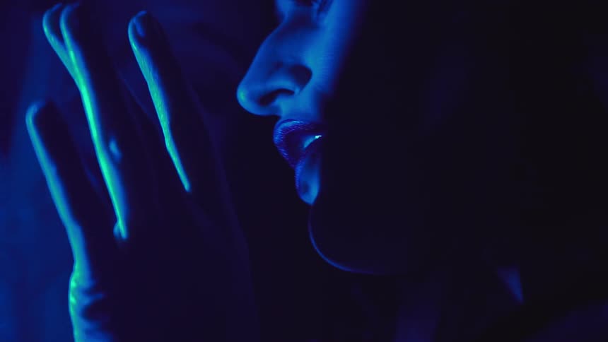 Woman's face illuminated by blue light
