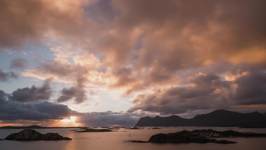 Puffy clouds float over the sea at sunset