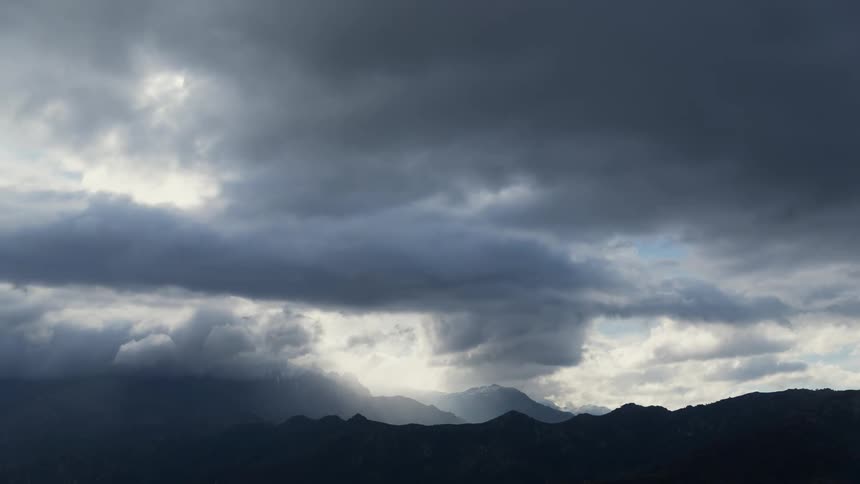 A dark cloudy sky above some mountains