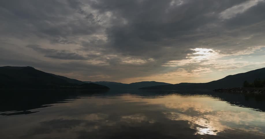 A rippling lake's surface reflects clouds in the morning