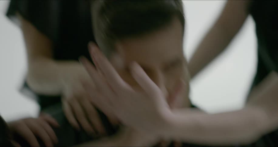 A man is having his face and shoulders rubbed by multiple people at once