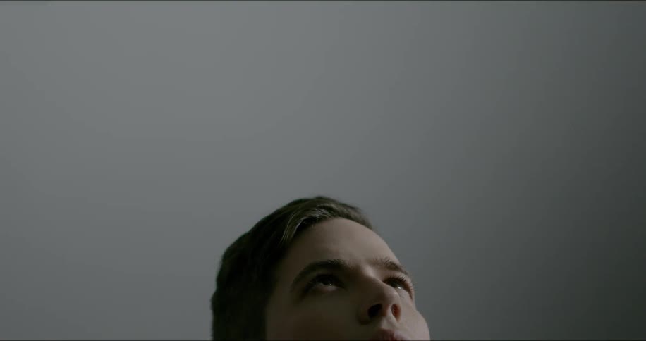 Face of man looking upwards while lights flicker