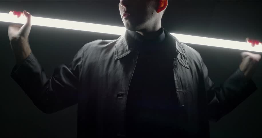 A man is holding a fluorescent bulb on his shoulders