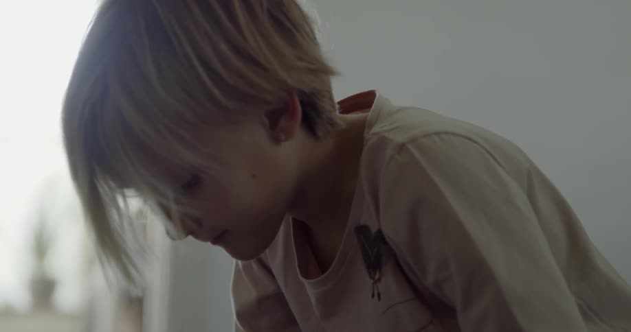 Child looks down talking to himself