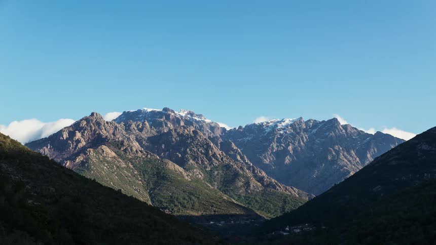 Clouds pass above a mountain