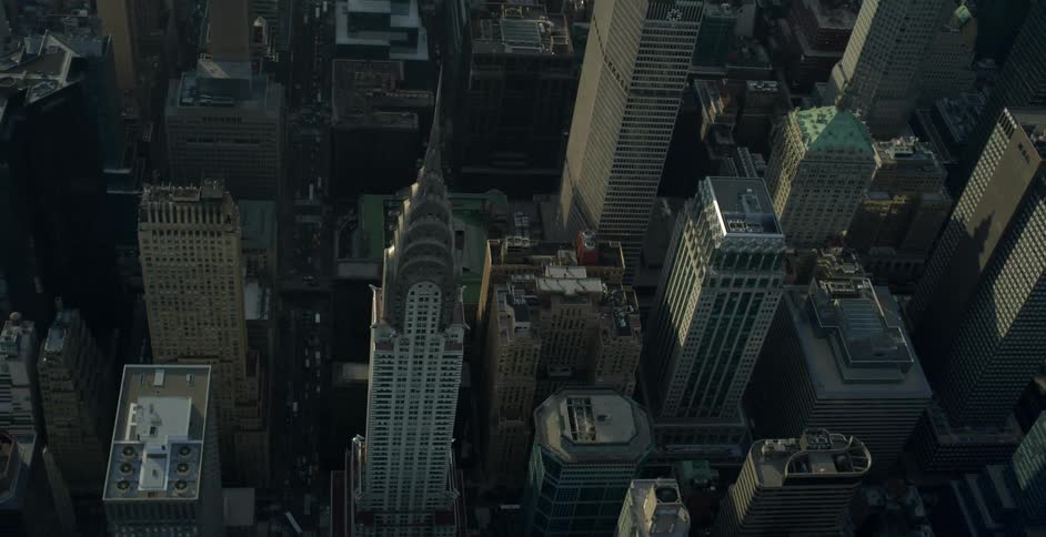 Aerial view of a city with many large buildings and cars driving below