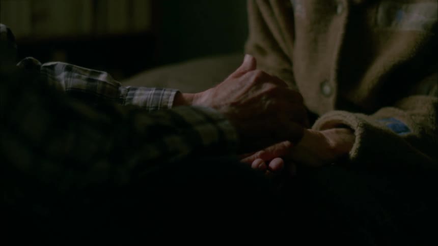 Older man rubbing the hands of older woman