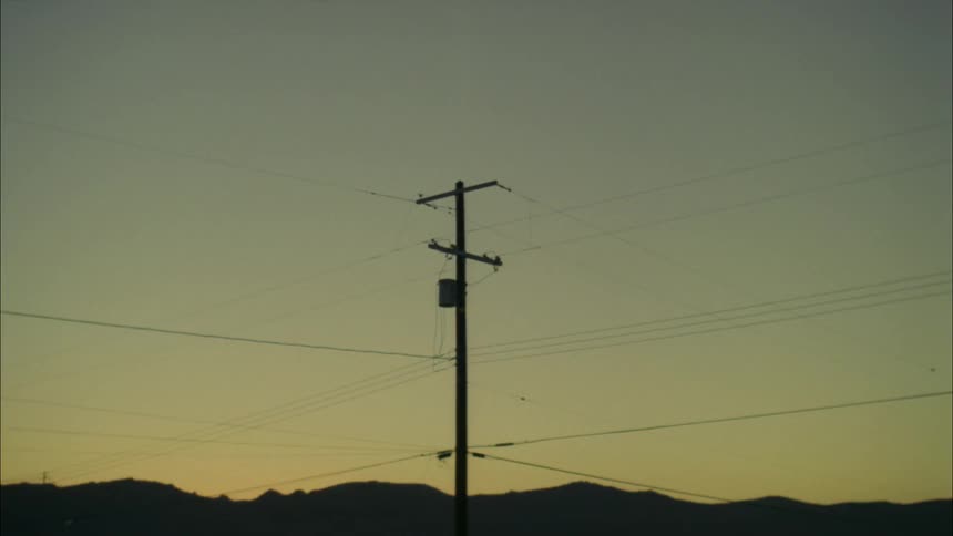 Several wires criss cross on a single telephone pole
