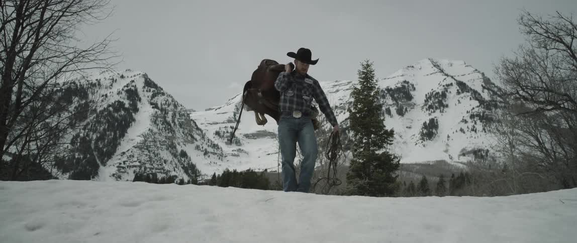 Man carrying a backpack walks up a snowy hill