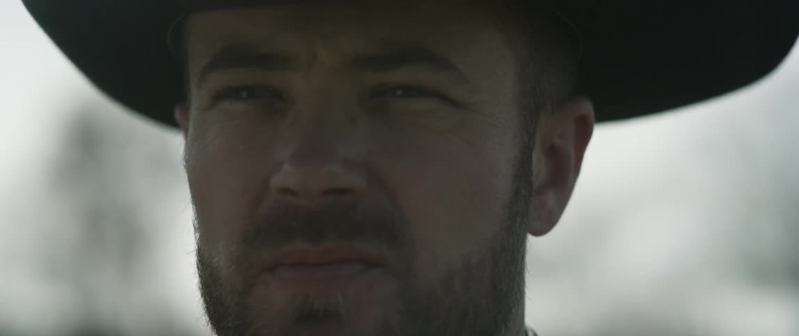Bearded cowboy face standing outdoors