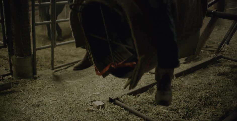 Mechanical bull bobbing up and down with a rider in a barn
