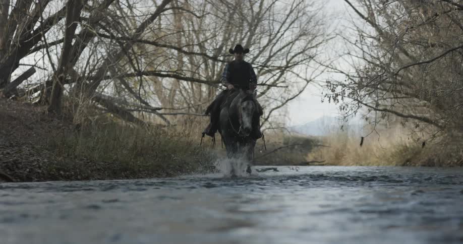A man is riding his horse down the long creek