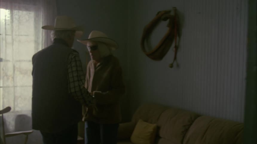 Two people walk down a hall and enter a room