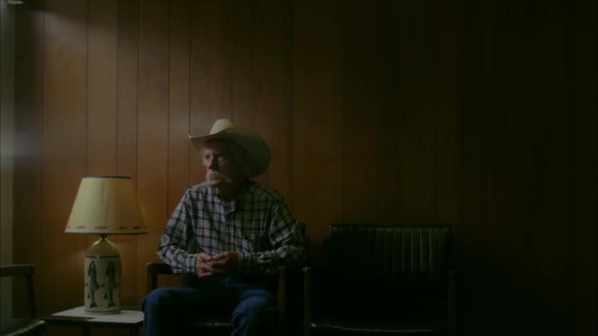 Elderly man sits in a chair in a waiting room