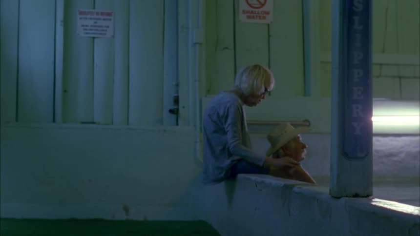 A couple sit by a pool together