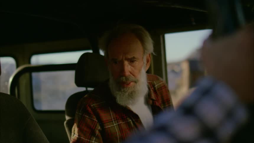 A man talks with someone from inside a car
