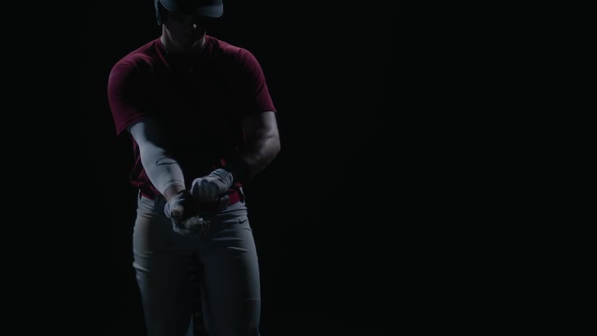 A man puts on baseball gloves at night