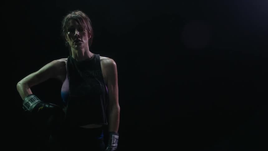 Woman wearing boxing gloves moves her arms around