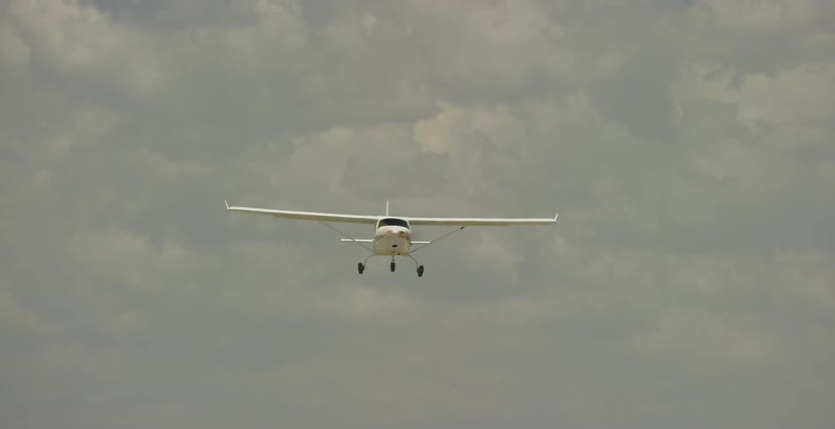 A propeller airplane takes off from a rural airstrip