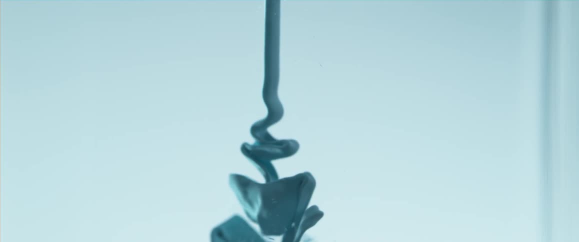 Thick blue fluid flowing through water