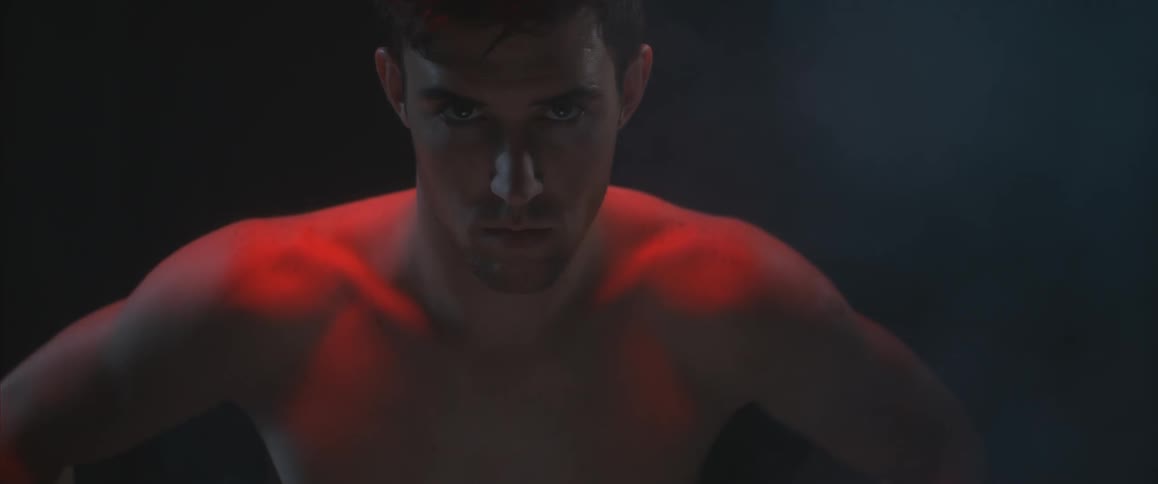 A shirtless man stares