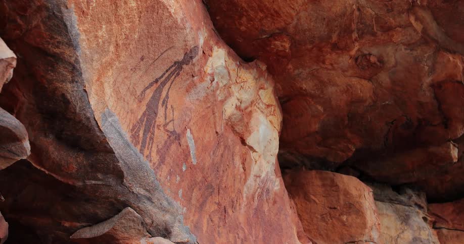 Red cave paintings on a rust colored rock