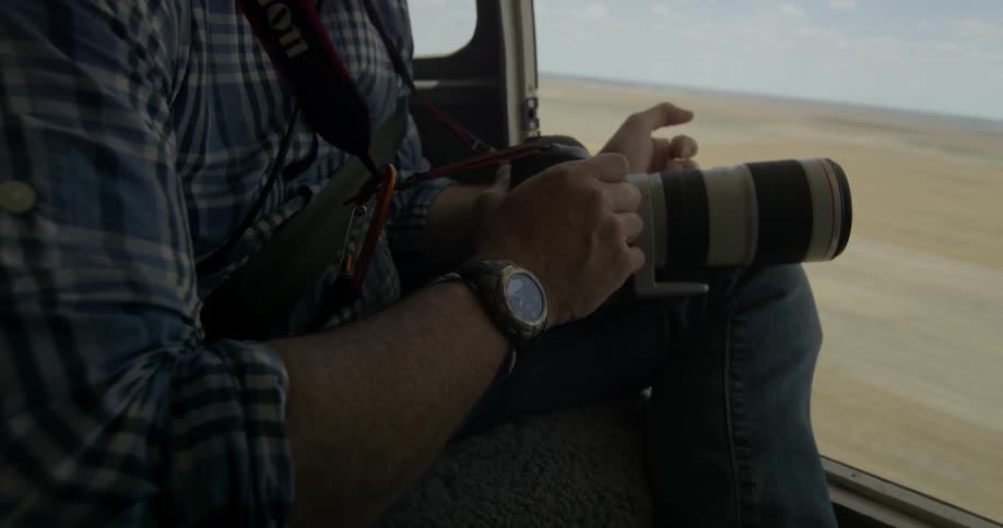 Man in plaid shirt holds camera