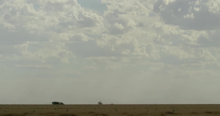 A truck drives past a field