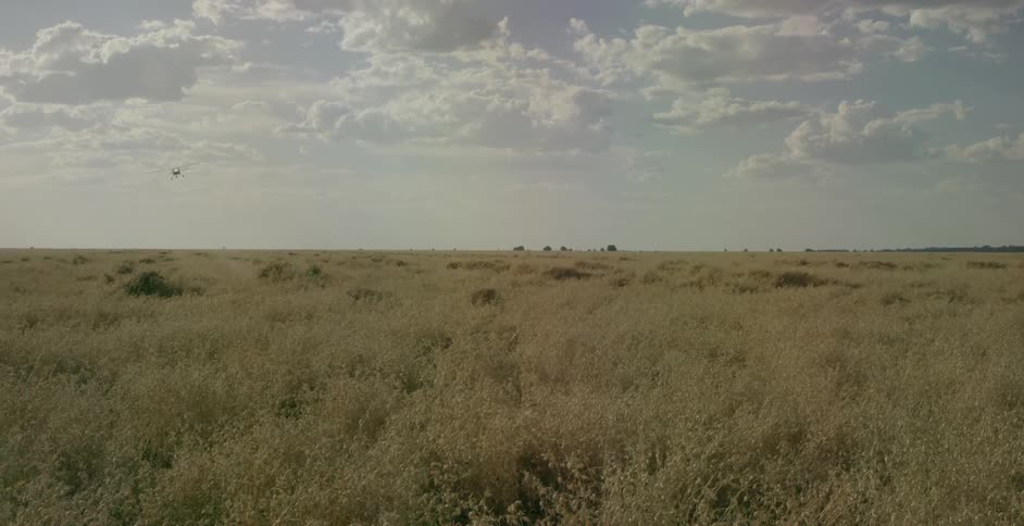 A plane flies over a large plains
