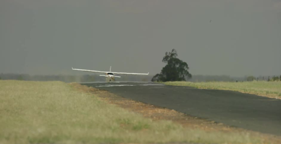 A plane rides down a narrow runway