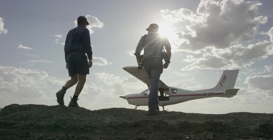 Men walk towards a small airplane