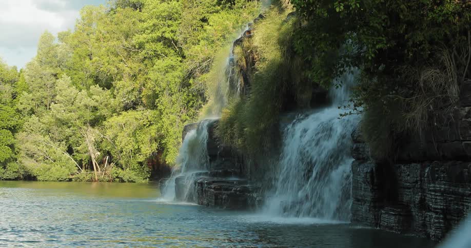 A waterfall dumps into a river
